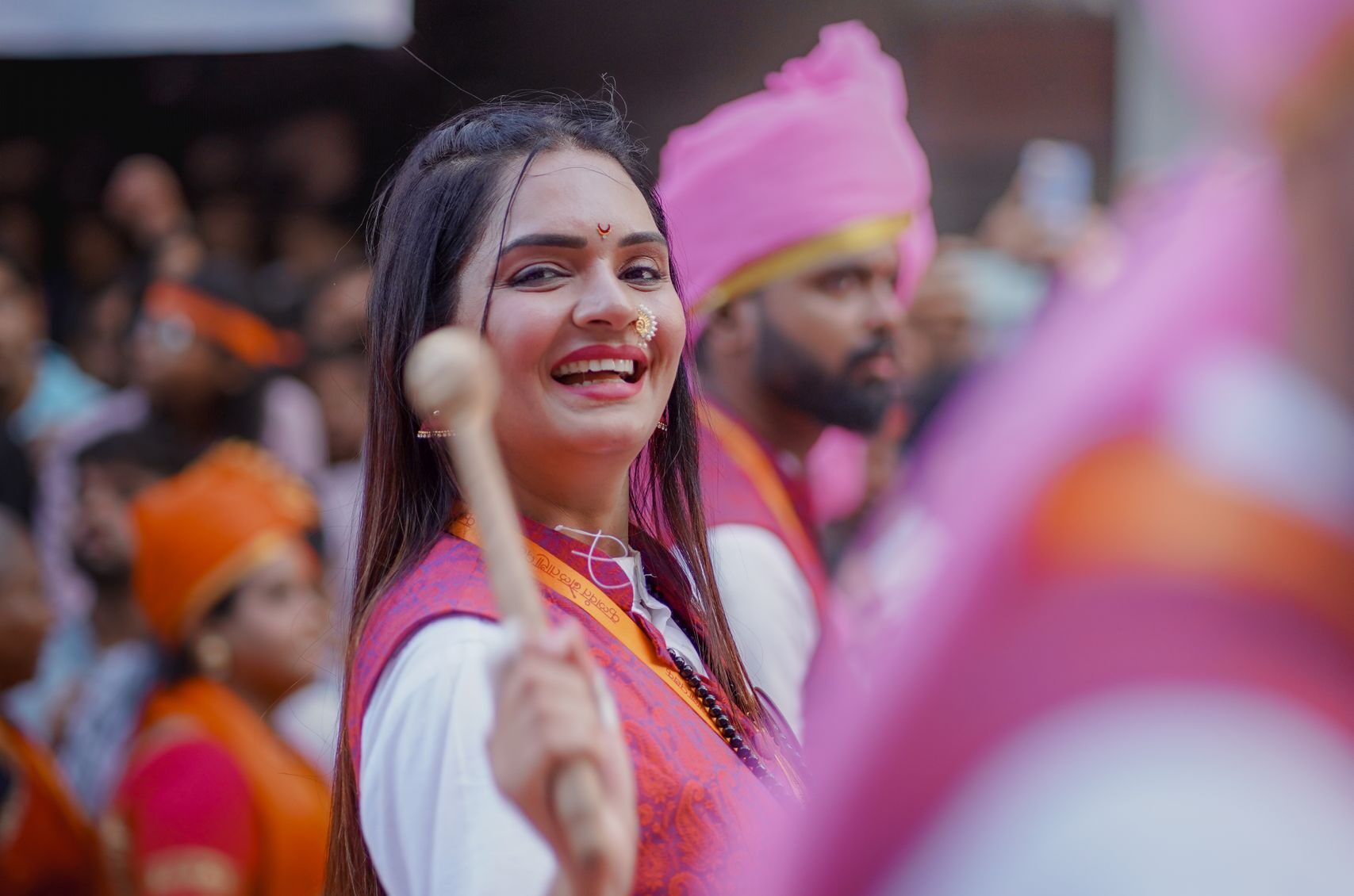 A joyful participant in a traditional festival parade in Pune, India, during Ganesh Chaturthi celebrations.